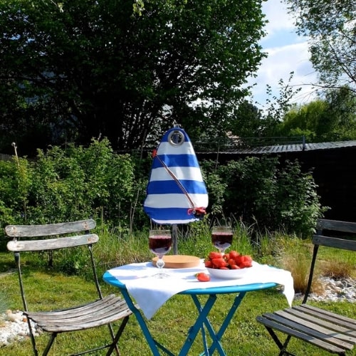 Fontaine à boisson Obag' rayée bleu et blanc sur une table de jardin