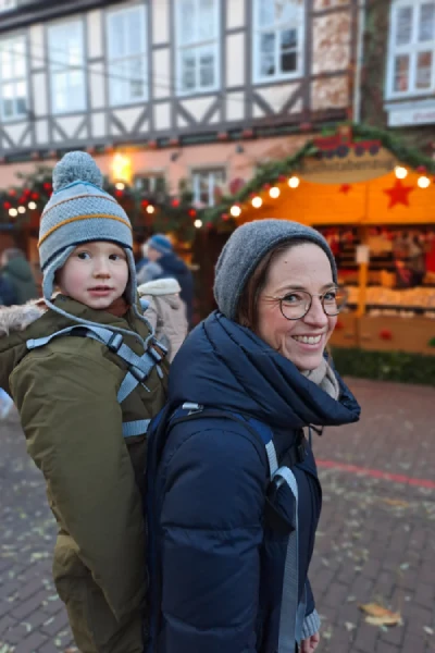 Mère portant son fils avec le porte bébé Homb sur un marché de Noël