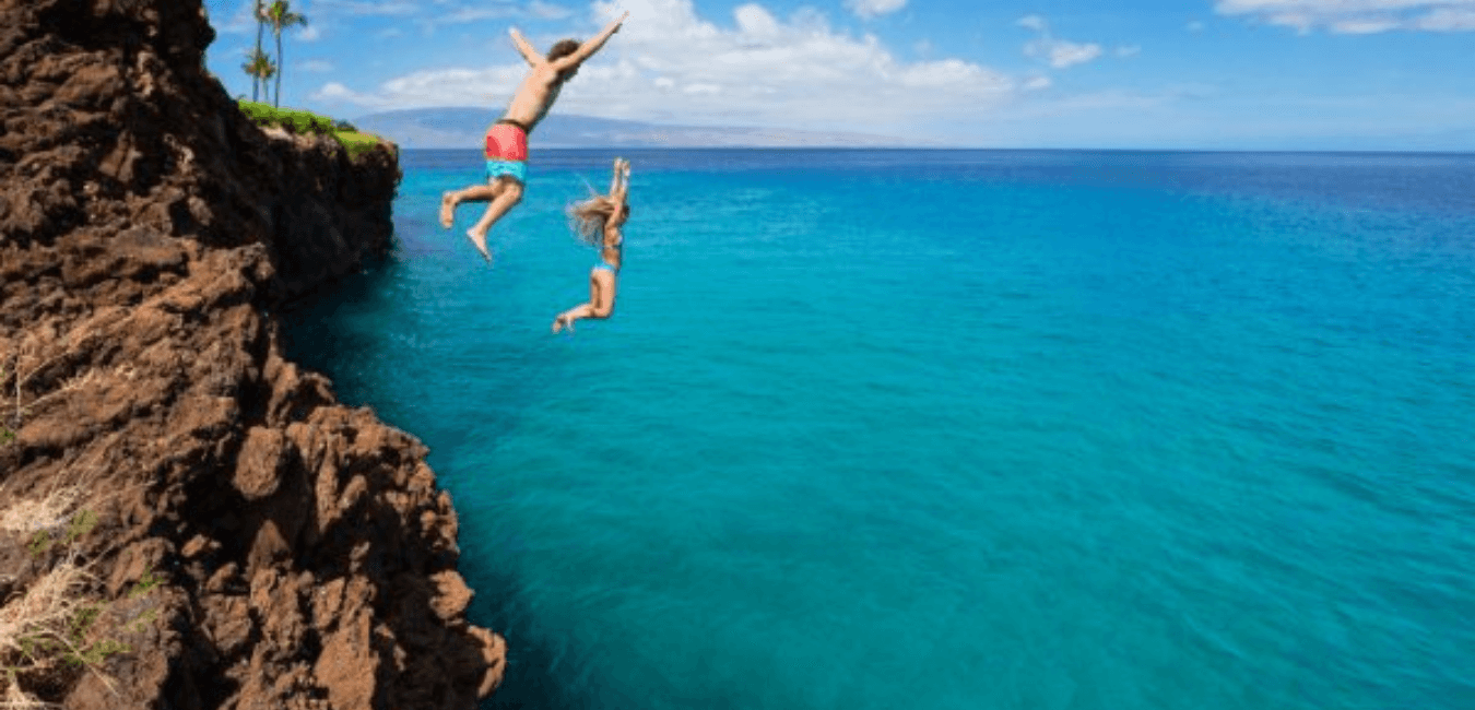 un homme et une femme en train de sauter d'une falaise