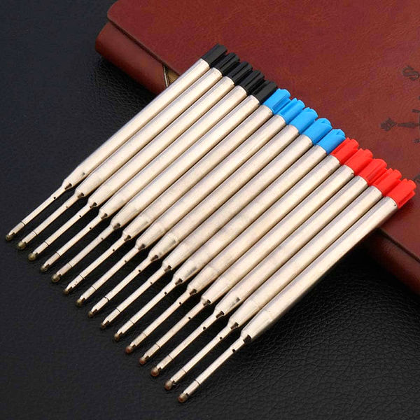 Recharges de stylo bille de différentes couleurs posé sur un carnet brun et sur un support noir