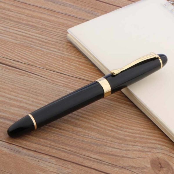stylo plume épais avec une plume doré sur un support en bois