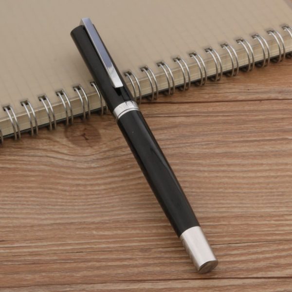 stylo plume avec plume argentée et dorée sur un support en bois