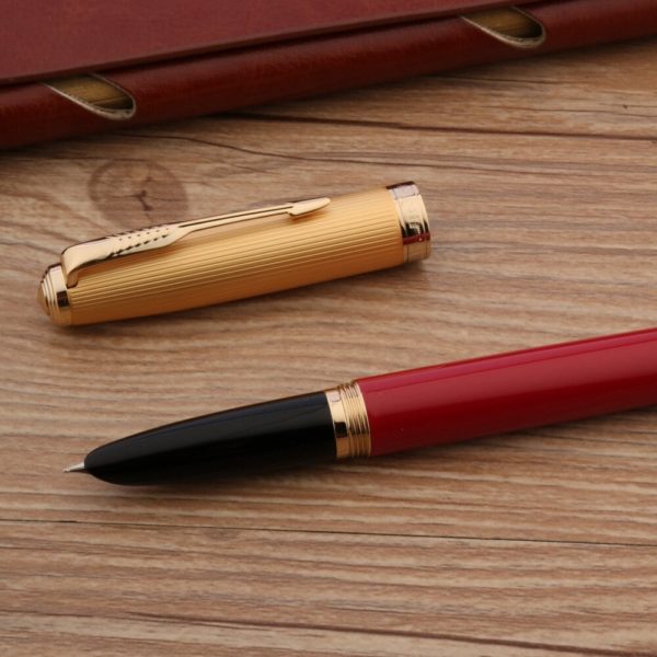 stylo à plume rouge de luxe sur un support en bois