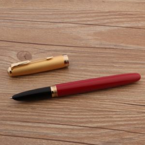 stylo à plume rouge de luxe sur un support en bois