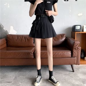 Fille qui porte une jupe plissée courte noire avec pochette, tee-shirt, baskets et chaussettes noires Kotoha
